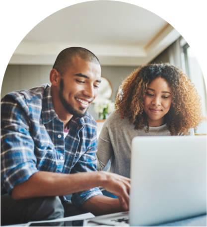 couple smiling while looking at laptop together