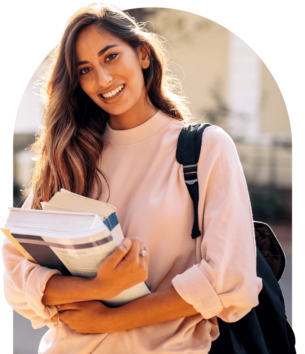 Woman smiling while holding textbooks