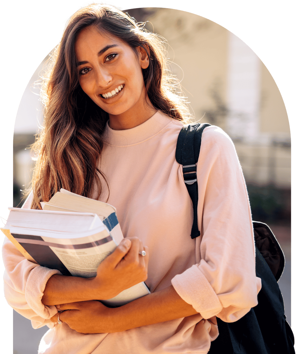 Woman smiling while holding textbooks