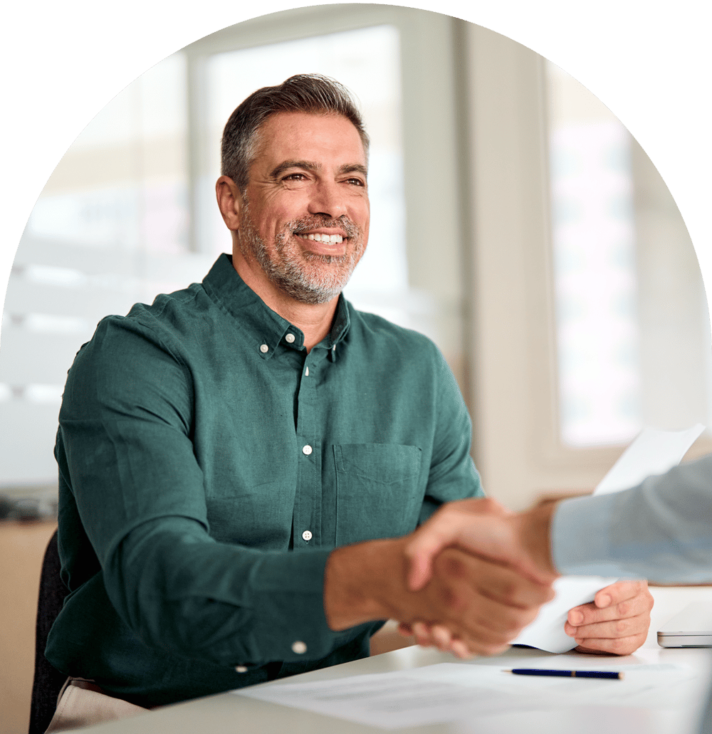 Man smiling while shaking hands with other person