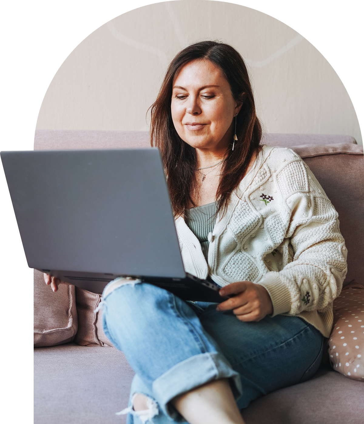 Woman on couch looking at laptop